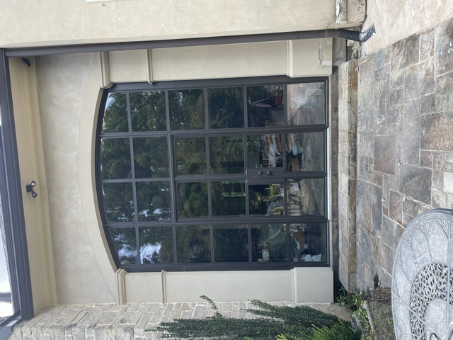 Arched black steel-and-glass double entry doors by West Little Rock Glass