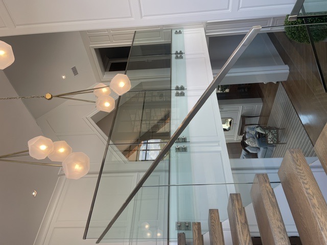 Glass stair and landing railing in a grand two-story foyer by West Little Rock Glass