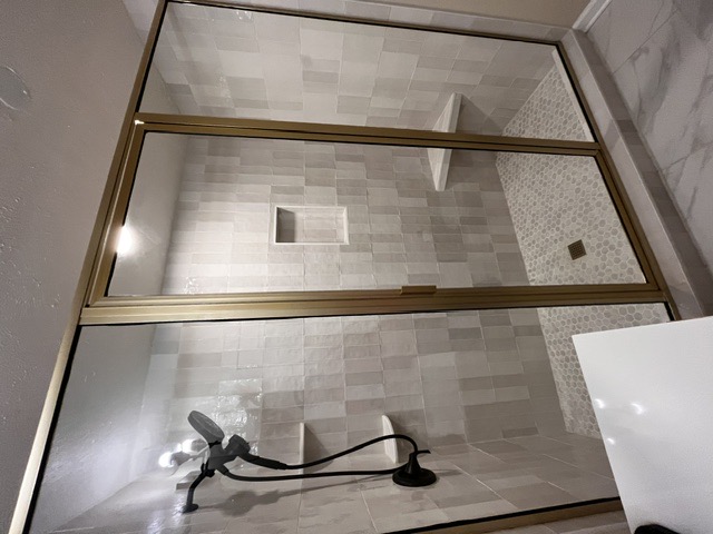 Gold-framed three-panel shower enclosure by West Little Rock Glass, serving Jacksonville