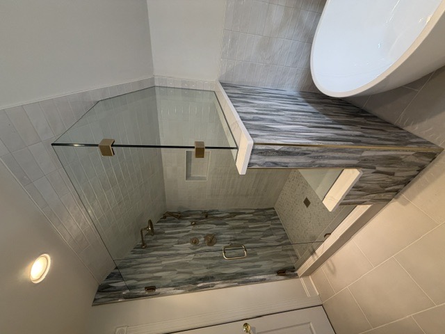 Angle-cut frameless shower glass fitted to a sloped ceiling by West Little Rock Glass