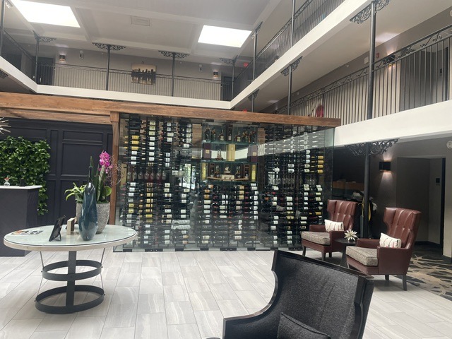 Glass-enclosed wine display wall in a hotel lobby by West Little Rock Glass